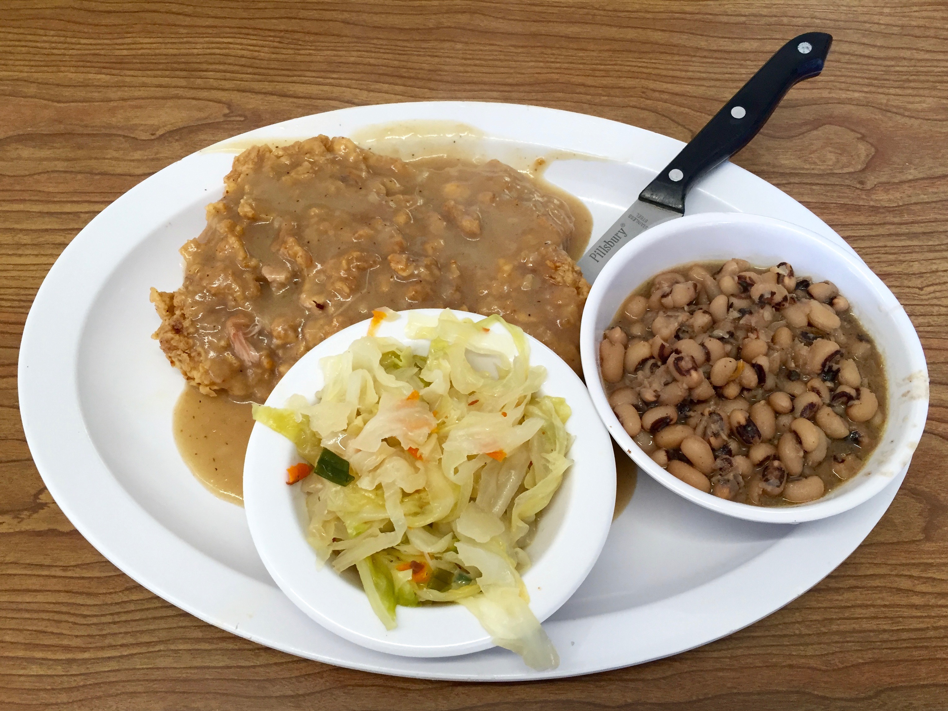 chicken fried steak with cabbage and black-eyed peas