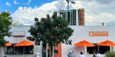 exterior of Matt's Big Breakfast with people waiting for tables and a construction crane in the background