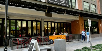 exterior of Adam's Table with customers on the patio and pedestrians walking on Adams Street