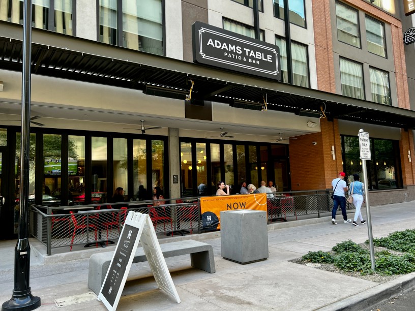 exterior of Adam's Table with customers on the patio and pedestrians walking on Adams Street