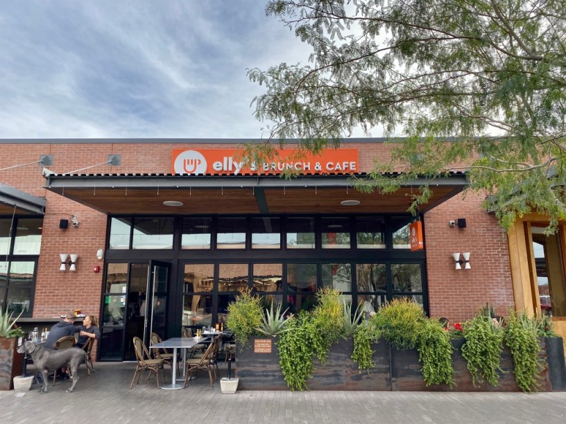 exterior of Elly's with customers and their dog on a shaded patio