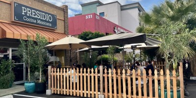 exterior of Presidio with shaded outdoor dining in front of the restaurant