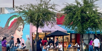 exterior of Lovebite with customers waiting in line outside and eating on tables along the sidewalk