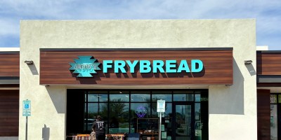 exterior of Hope's Frybread with a merchant setting up a display table of craft items