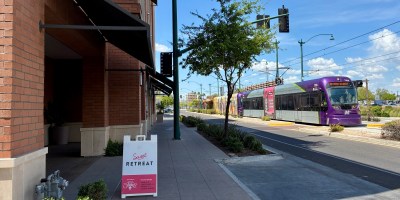 exterior of Sweet Retreat with a light rail train approach via Main Street