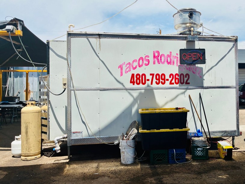 Back side of a trailer with "Tacos Rodgriguez" printed on a white surface.