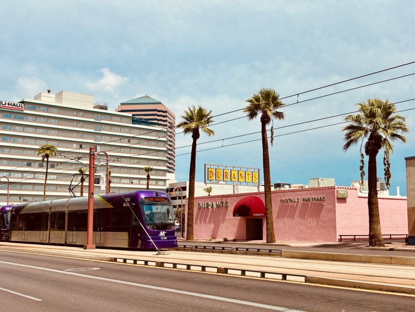 Exterior of Durant's as seen from Central Avenue with a light rail train passing the restaurant