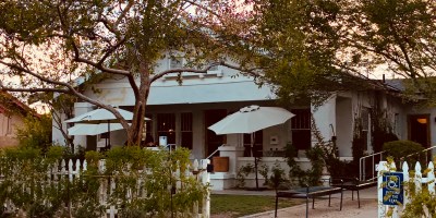 exterior of Matilda's with shade trees and diners eating on the patio