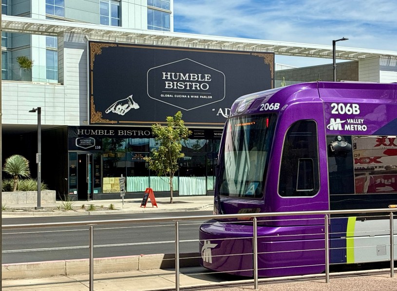 exterior of Humble Bistro with a light rail train passing in front of the restaurant